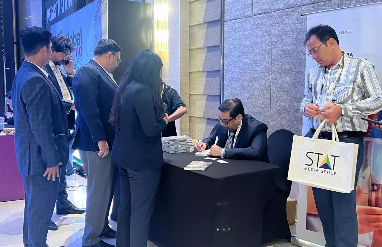 Dr Ravi Prakash Mathur signing copies of his book after the launch at Global Pharma Logistics Summit 2024, an event organised by Indian Transport and Logistics News. 